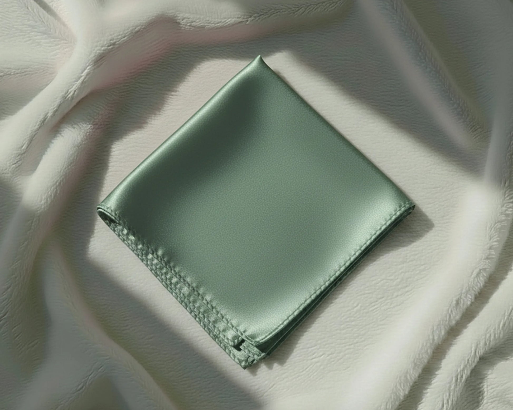 Green fabric square on a textured beige surface