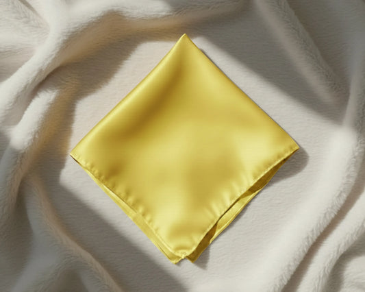 Yellow satin square on a textured white surface