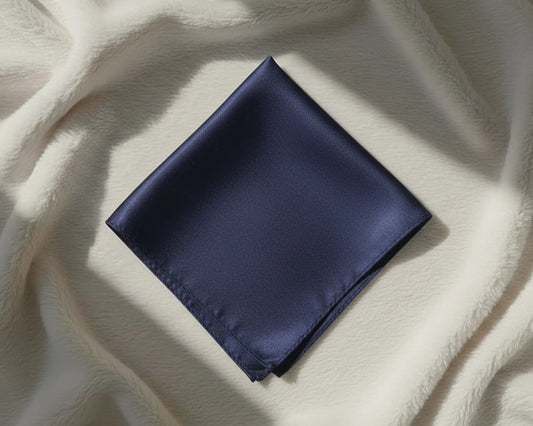 Navy blue pocket square on a textured beige fabric background