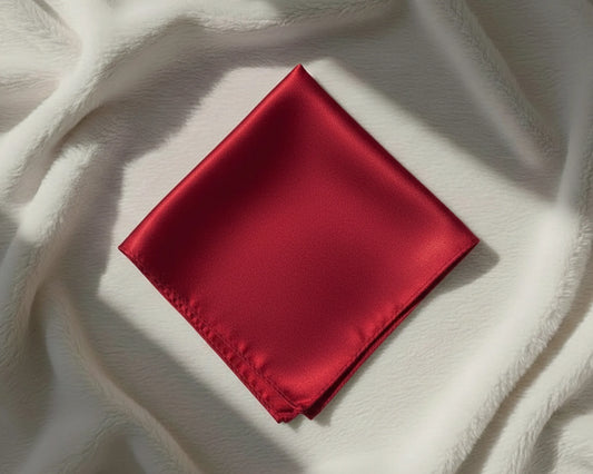 Red satin pocket square on a textured white fabric background