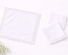 Two white lace trimmed pillows on a light gray background