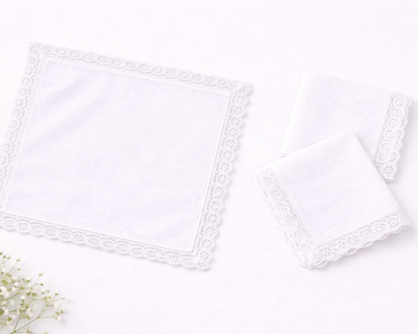 Two white lace trimmed pillows on a light gray background