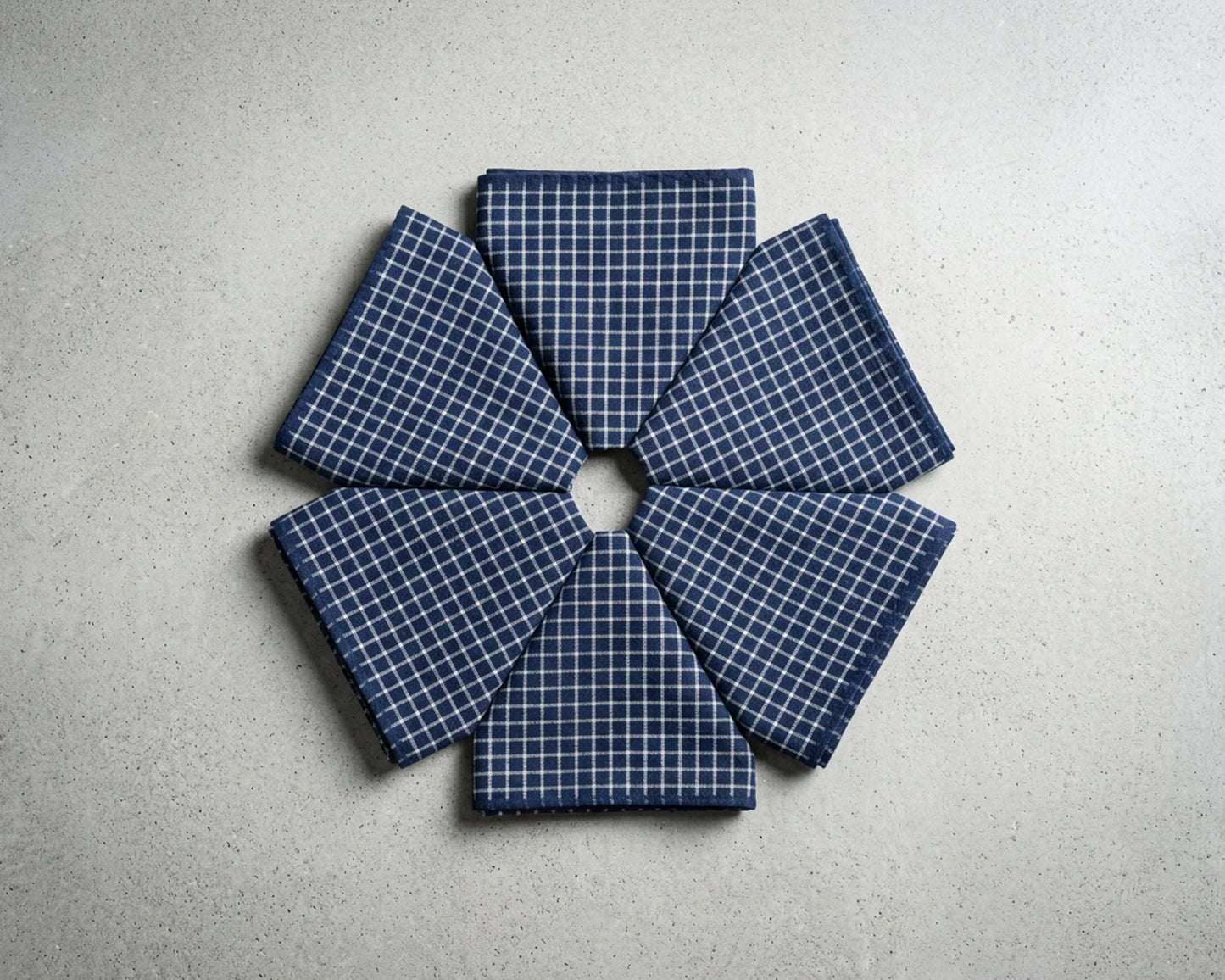Set of blue checkered handkerchief arranged in a circular pattern on a light gray surface.
