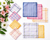 Set of colorful checkered coasters with flowers on a white background