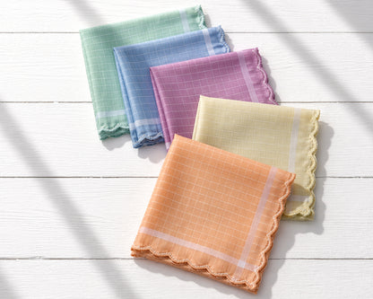 Set of colorful checkered handkerchiefs on a white wooden surface