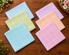 Set of colorful checkered hanky on a wooden surface with flowers around.