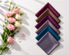 Set of colorful satin hanky arranged in a pyramid shape with flowers on a light background