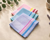 Set of colorful hanky on a light surface with greenery in the background