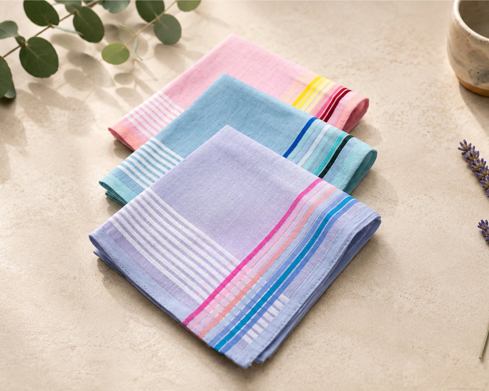 Set of colorful hanky on a light surface with greenery in the background