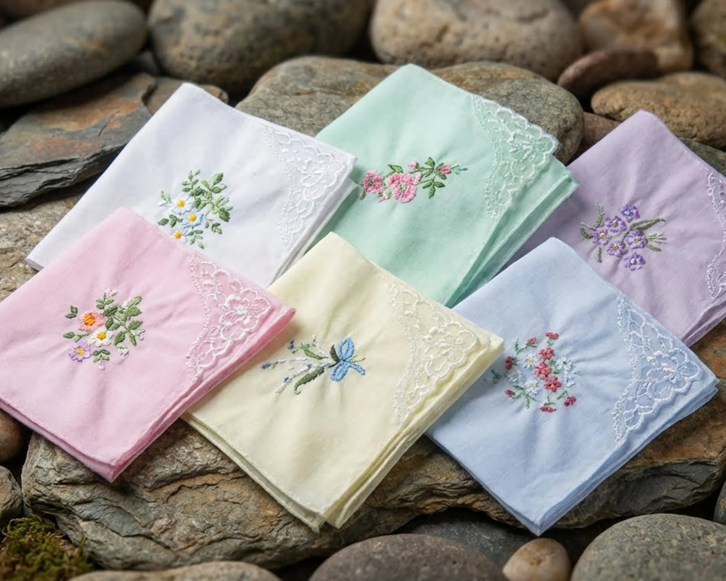 Set of embroidered handkerchiefs in various colors on a stone surface