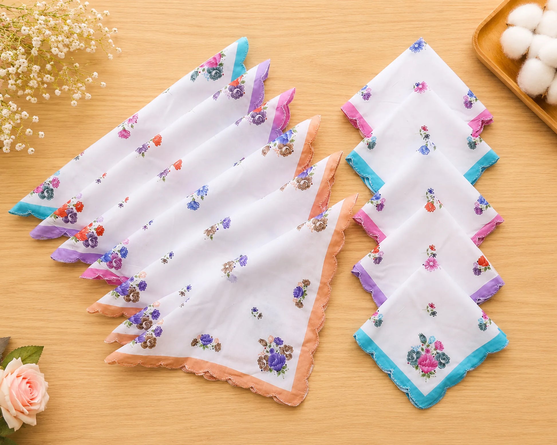 Set of floral printed handkerchiefs on a wooden surface with decorative elements.