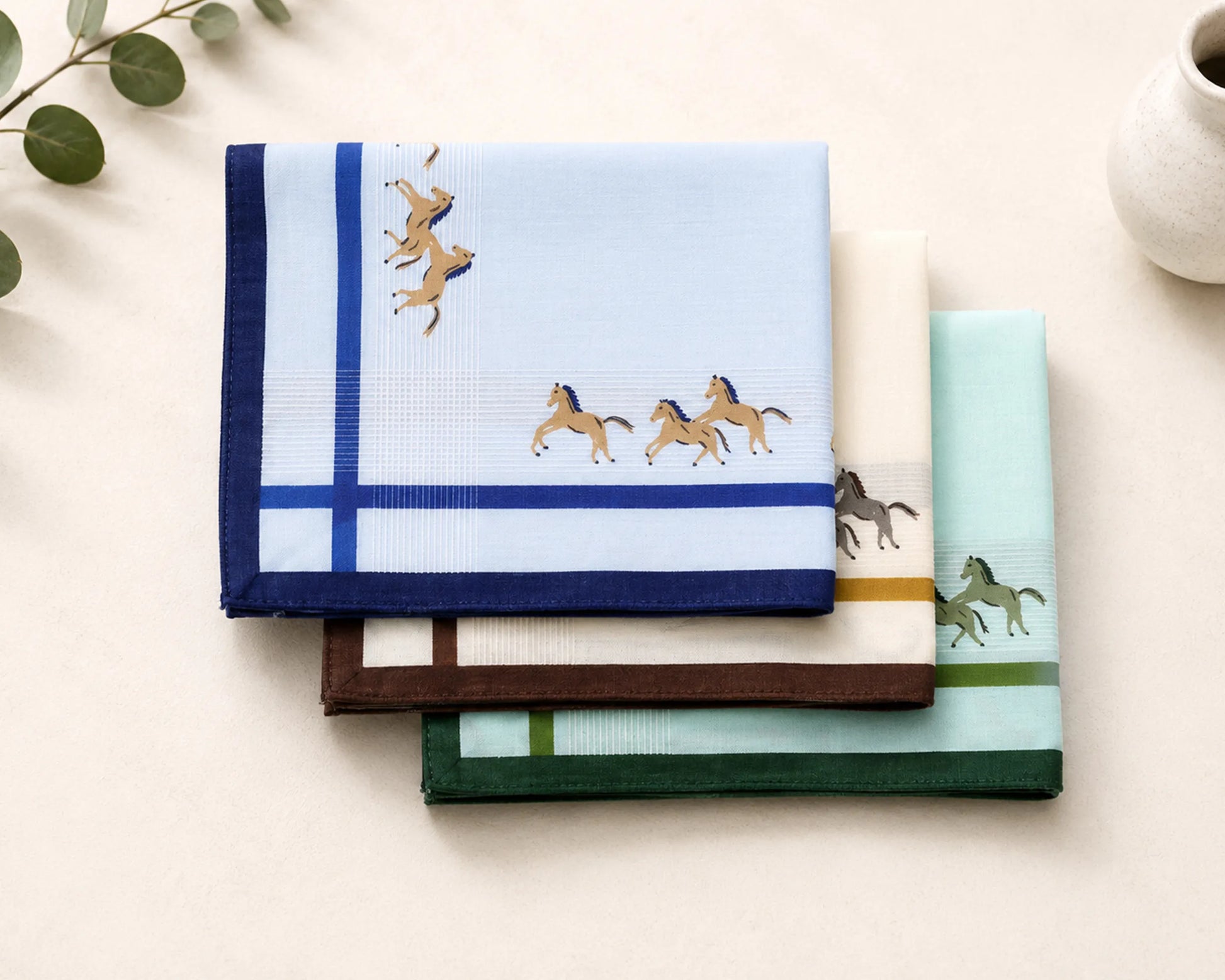 Set of folded cotton hanky with horse designs on a light surface.