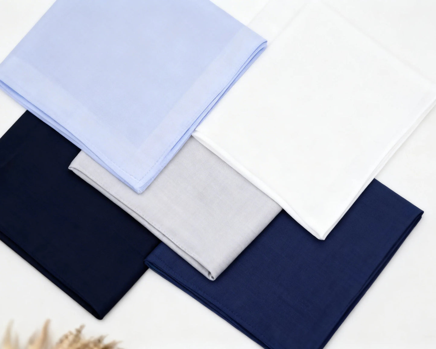 Set of folded hanky in blue, navy, and gray on a white background