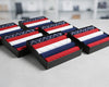 Set of folded hanky in red, white, and blue packaging on a blurred indoor background