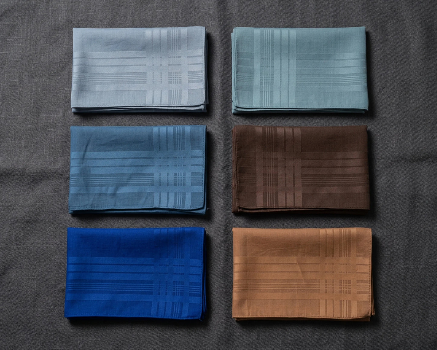 Set of folded hanky in various colors on a dark surface