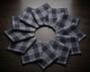 Set of gray checkered hanky arranged in a circular pattern on a wooden surface.