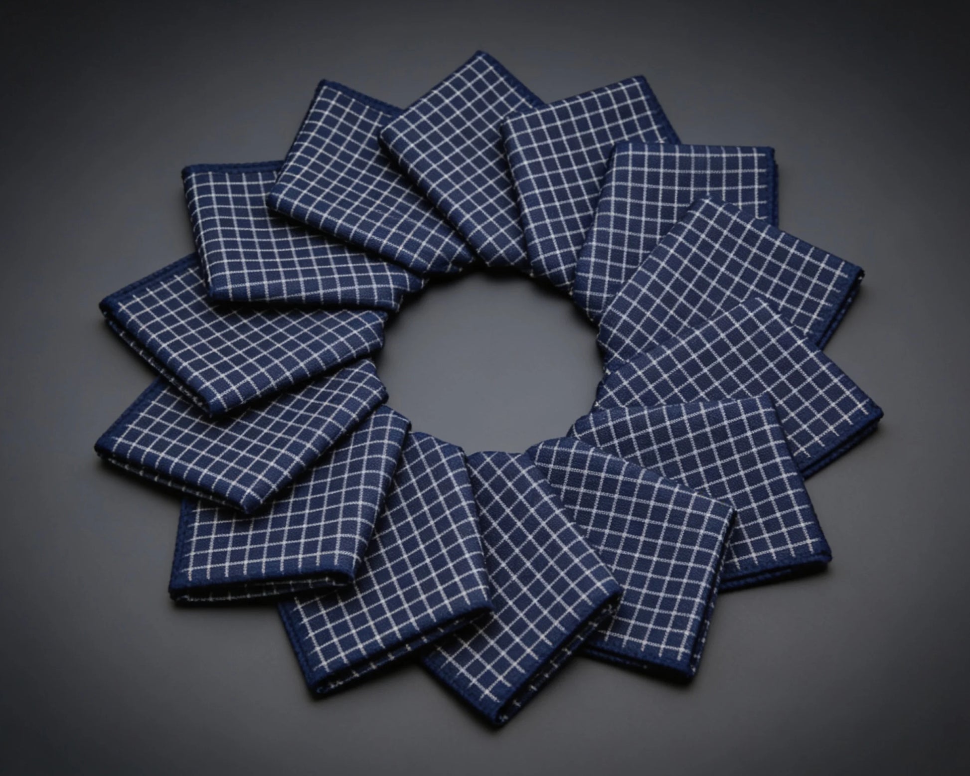 Set of gray checkered hanky arranged in a circular pattern on a wooden surface.