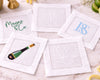 Set of personalized cocktail napkins with various designs on a marble surface.