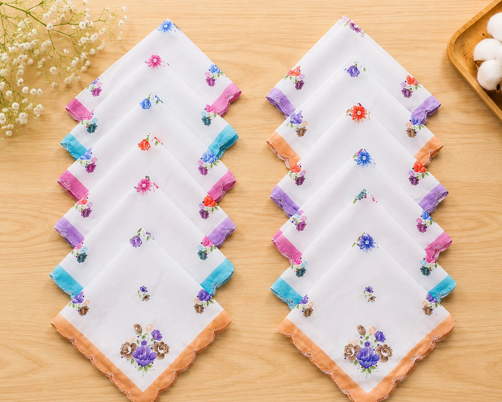 Set of embroidered handkerchiefs on a wooden surface with flowers in the background