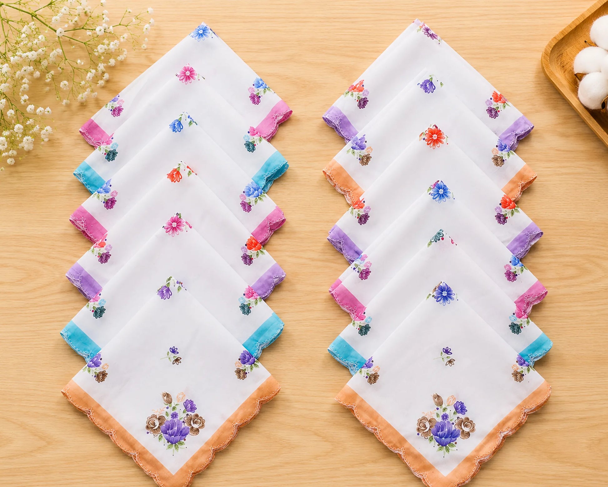 Set of embroidered handkerchiefs on a wooden surface with flowers in the background