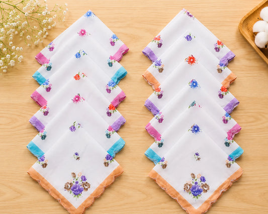 Set of embroidered handkerchiefs on a wooden surface with flowers in the background