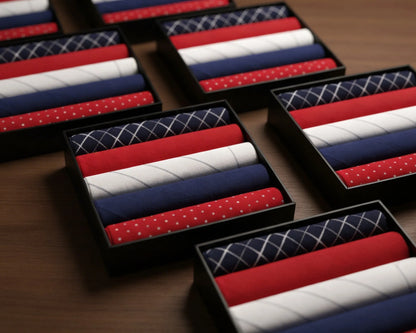 Set of red, white, and blue patterned hanky in black boxes on a wooden surface