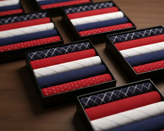 Set of red, white, and blue patterned hanky in black boxes on a wooden surface
