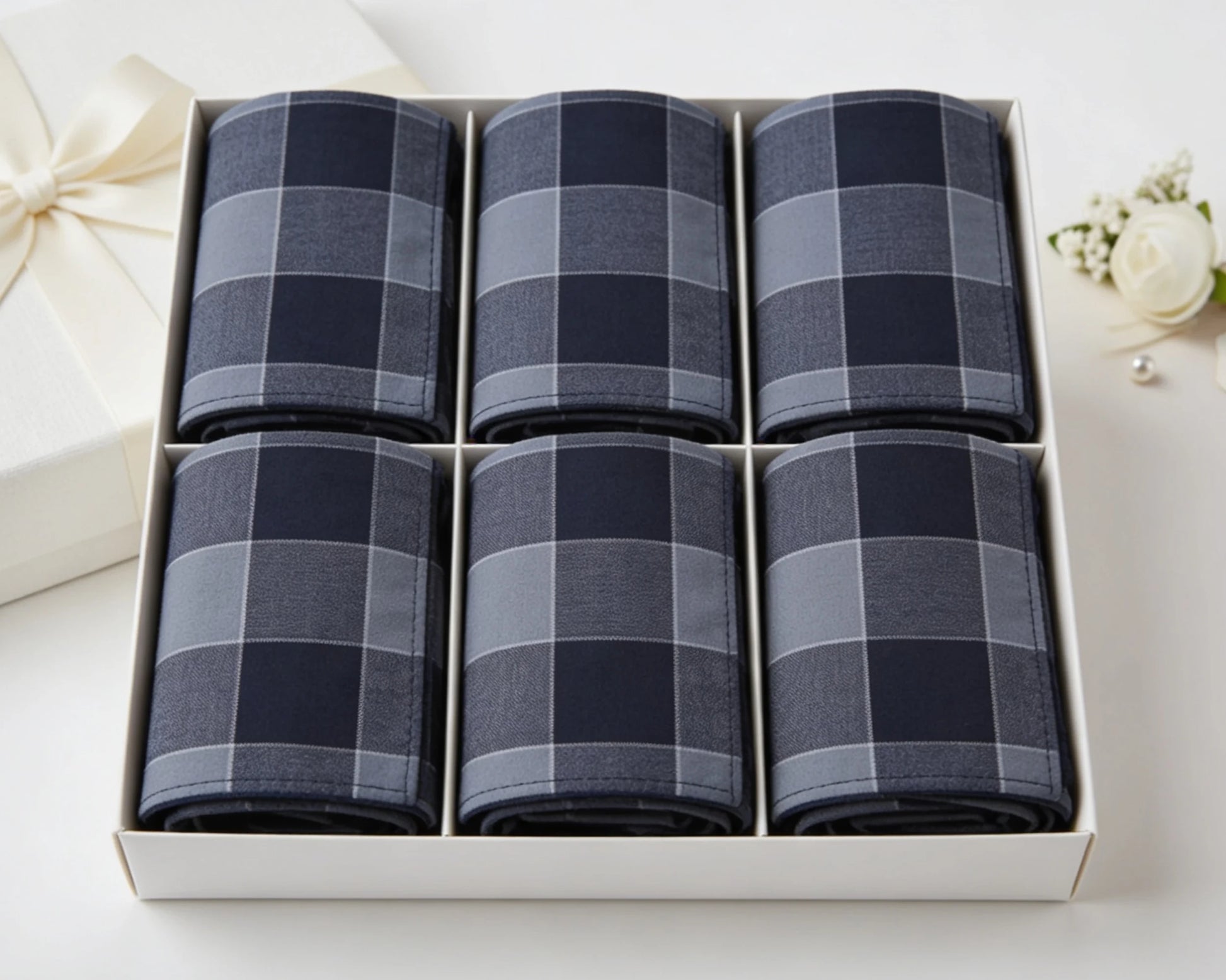 Set of six blue checkered handkerchiefs in a white box on a white background.