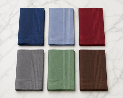 Set of six folded hanky  in blue, gray, green, red, and brown on a marble surface.