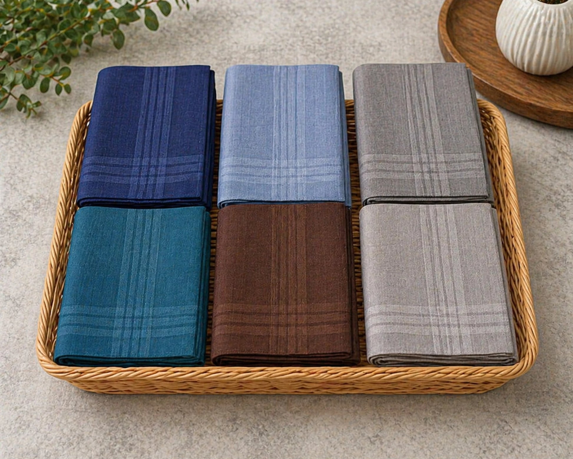 Set of six folded hanky in blue, gray, green, red, and brown on a marble surface.