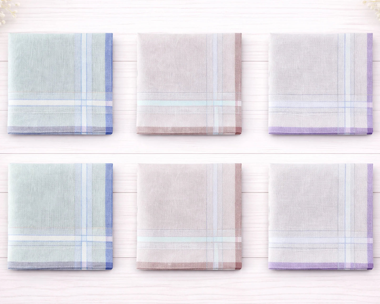 Set of six plaid handkerchiefs in pastel colors on a white wooden background