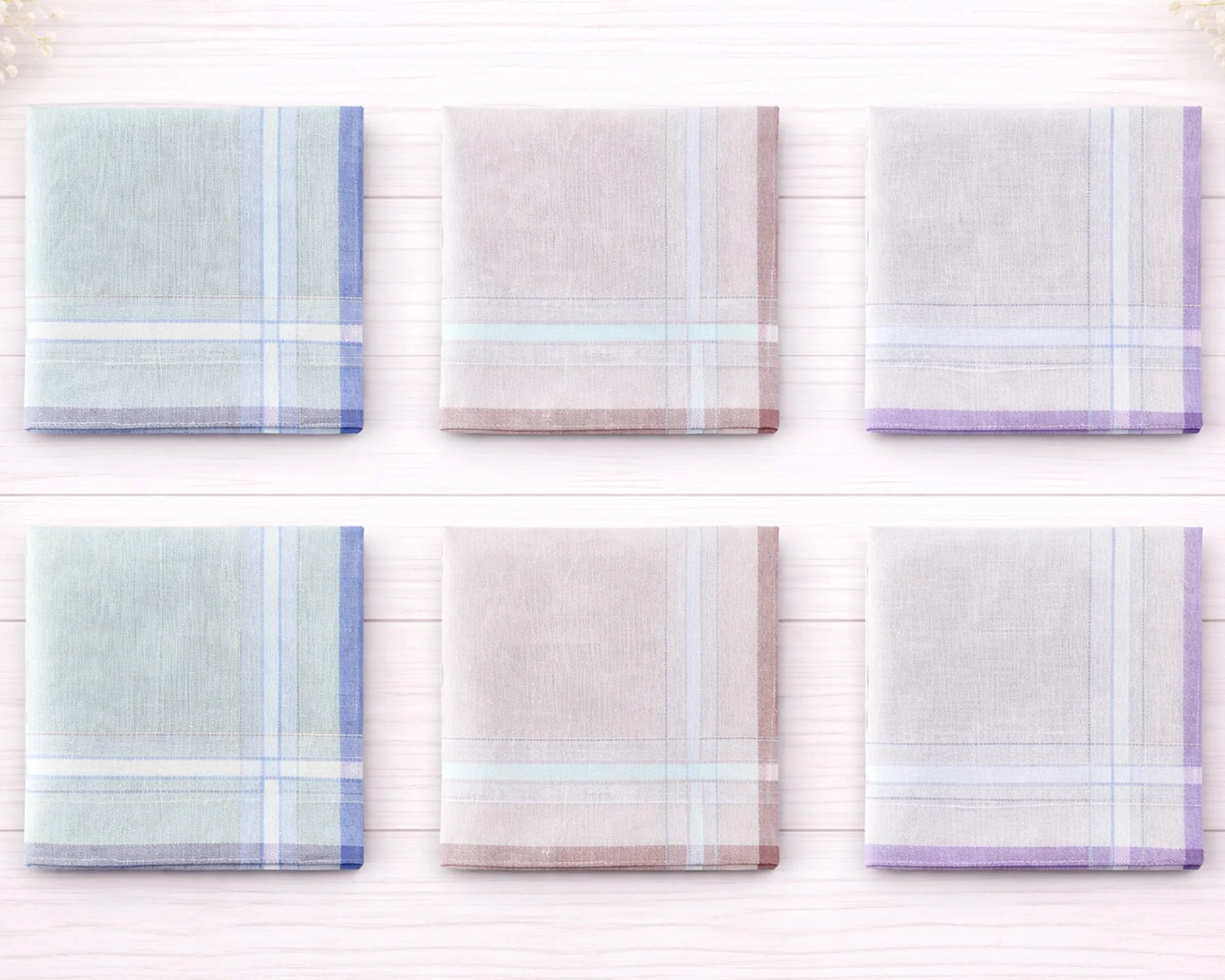 Set of six plaid handkerchiefs in pastel colors on a white wooden background