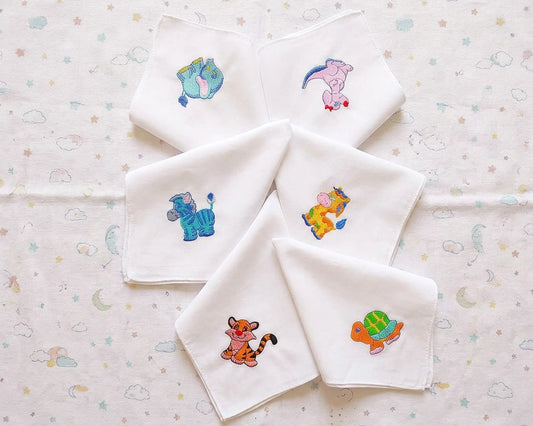 Set of white baby hanky with embroidered animal designs on a patterned background