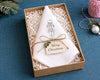 Set of white cocktail napkins with a martini glass design on a wooden surface.