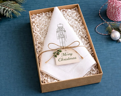 Set of white cocktail napkins with a martini glass design on a wooden surface.
