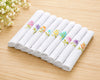 Set of white handkerchiefs with colorful floral embroidery on a wooden surface.