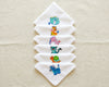Set of white hanky with embroidered animal designs on a beige fabric background