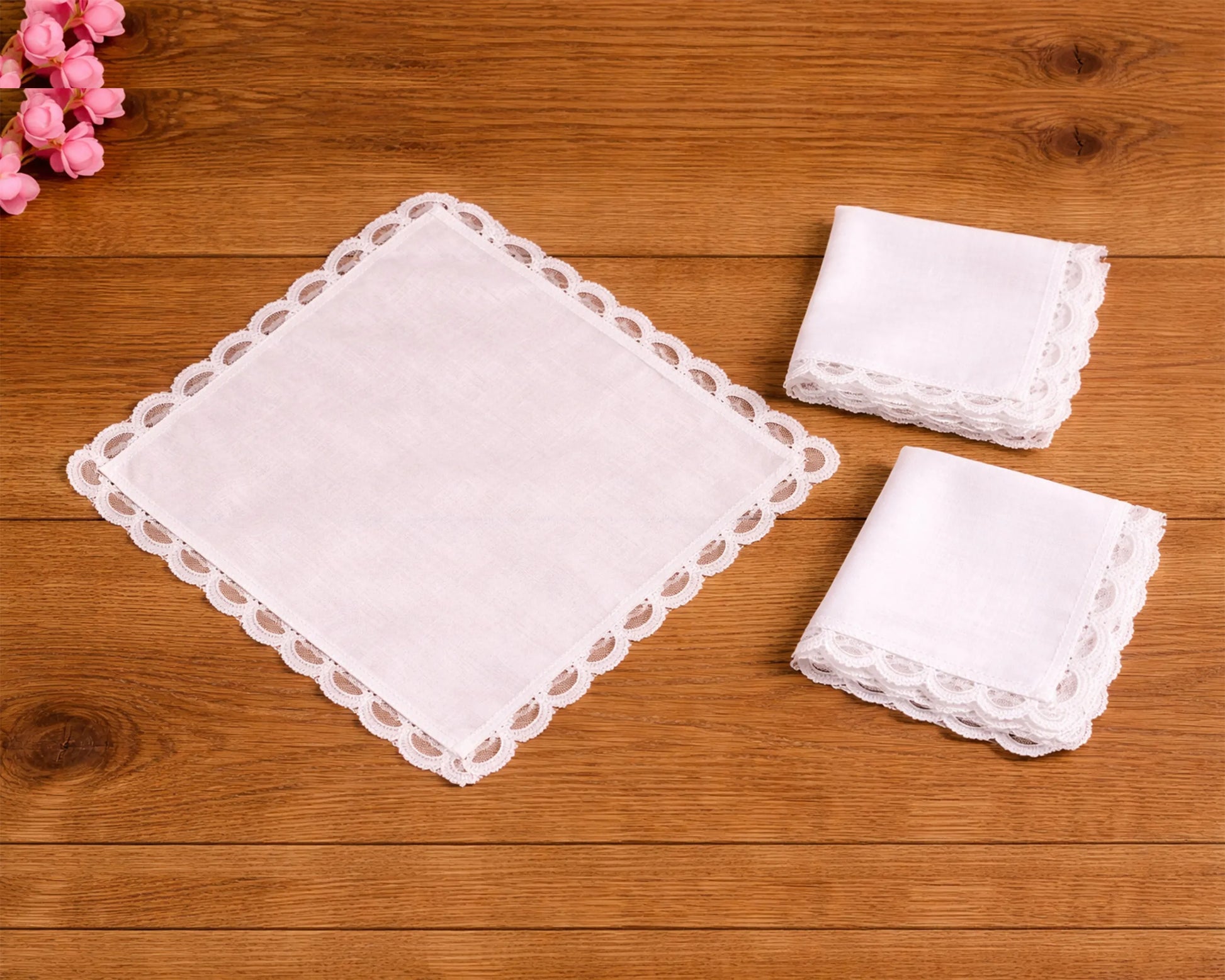 Set of white lace handkerchiefs on a wooden surface