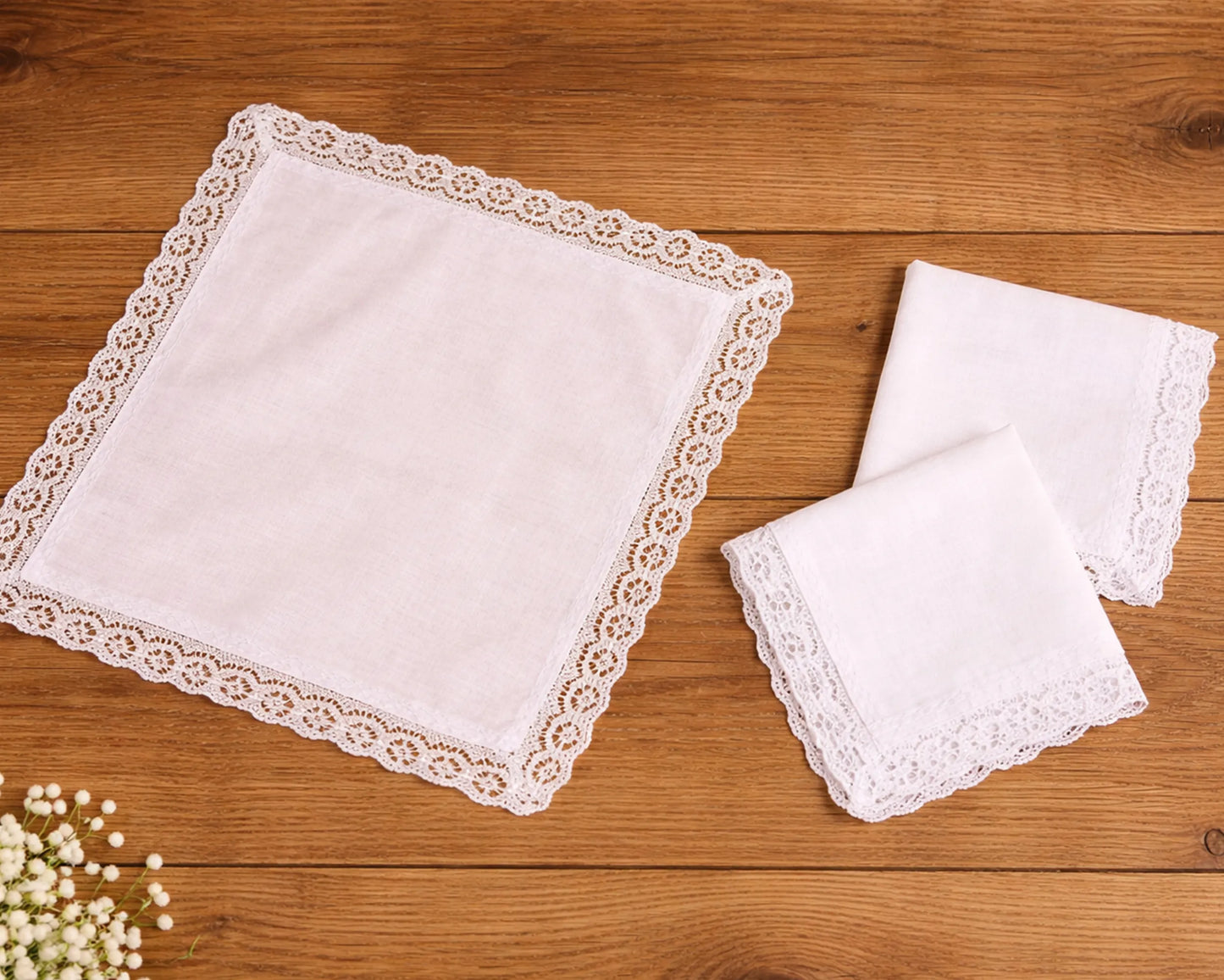 Set of white lace trimmed handkerchiefs on a wooden surface