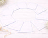 Set of white hanky on a light wooden surface with decorative elements.
