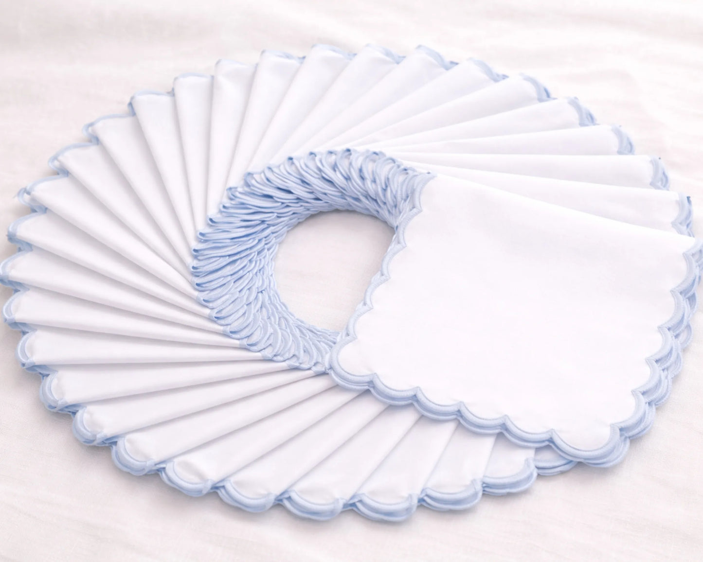 Set of white toilet seat covers with blue trim on a light gray background