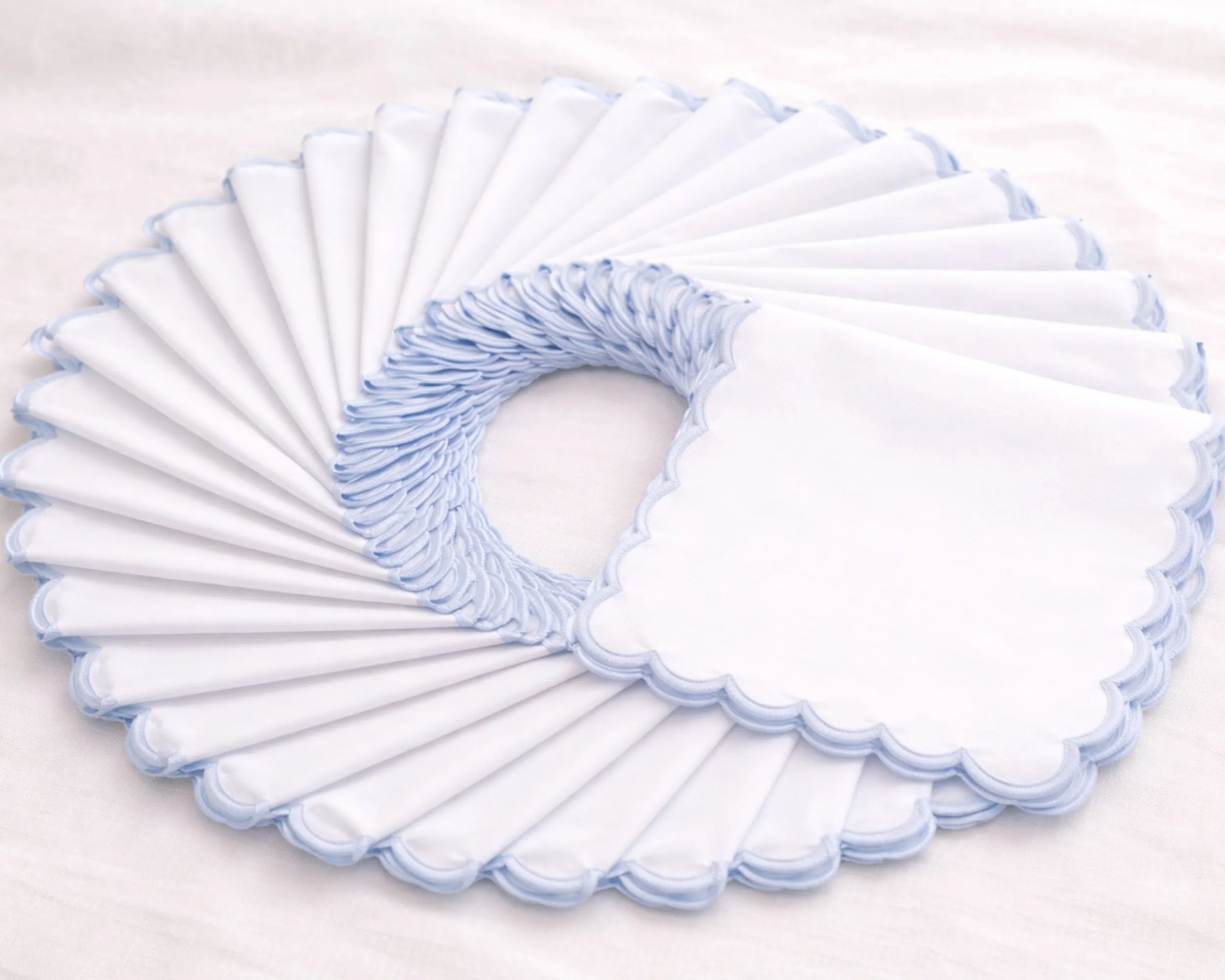 Set of white toilet seat covers with blue trim on a light gray background