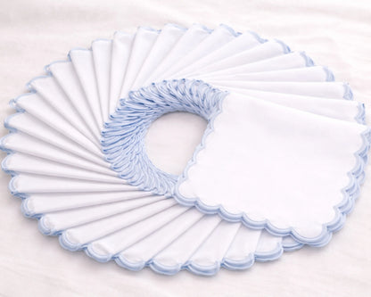 Set of white toilet seat covers with blue trim on a light gray background