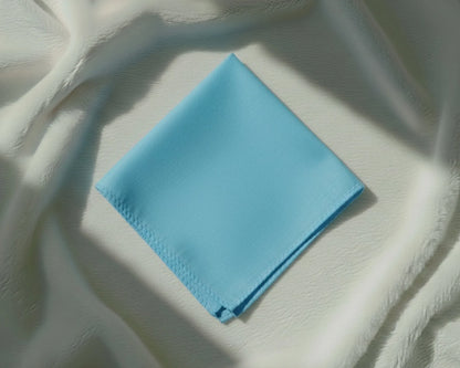 Light blue fabric square on a textured white surface