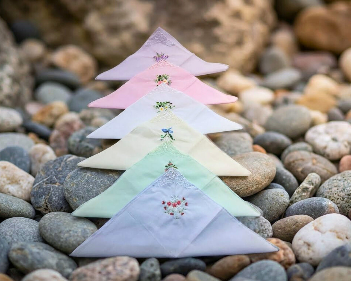 Small embroidered triangle flags on a bed of stones