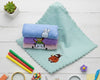 Single teal plush hankerchief for children featuring a small bear icon and wavy edges