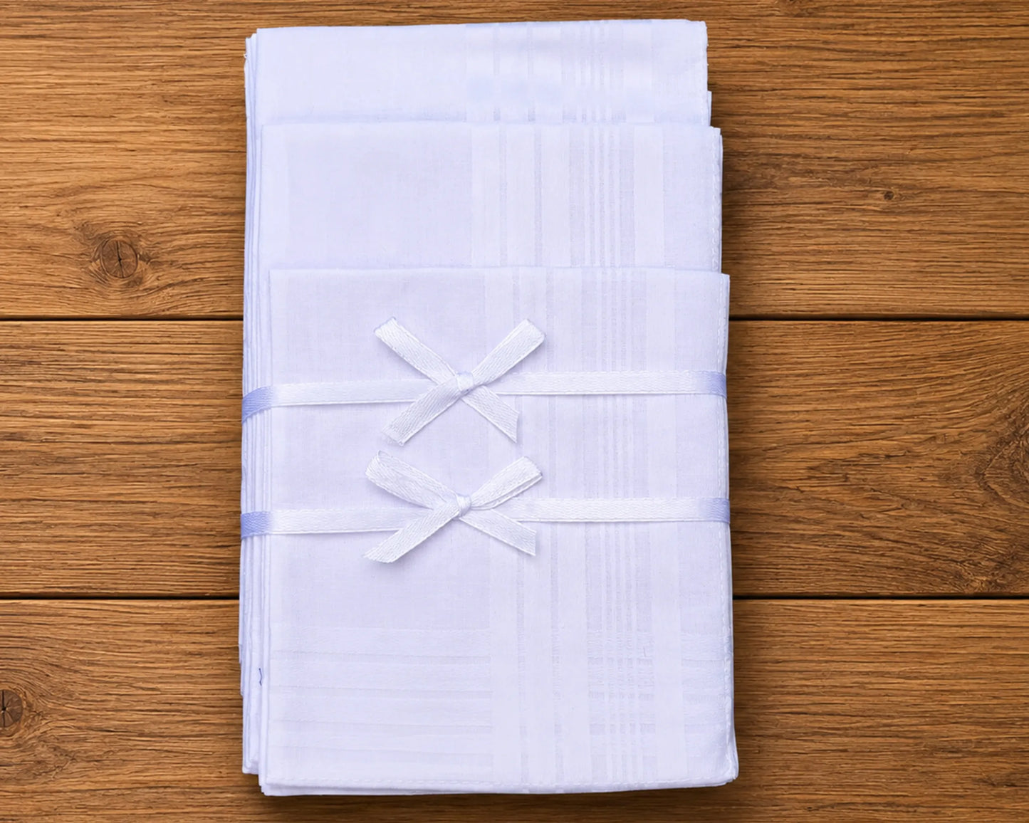 Stack of white folded hanky on a wooden surface