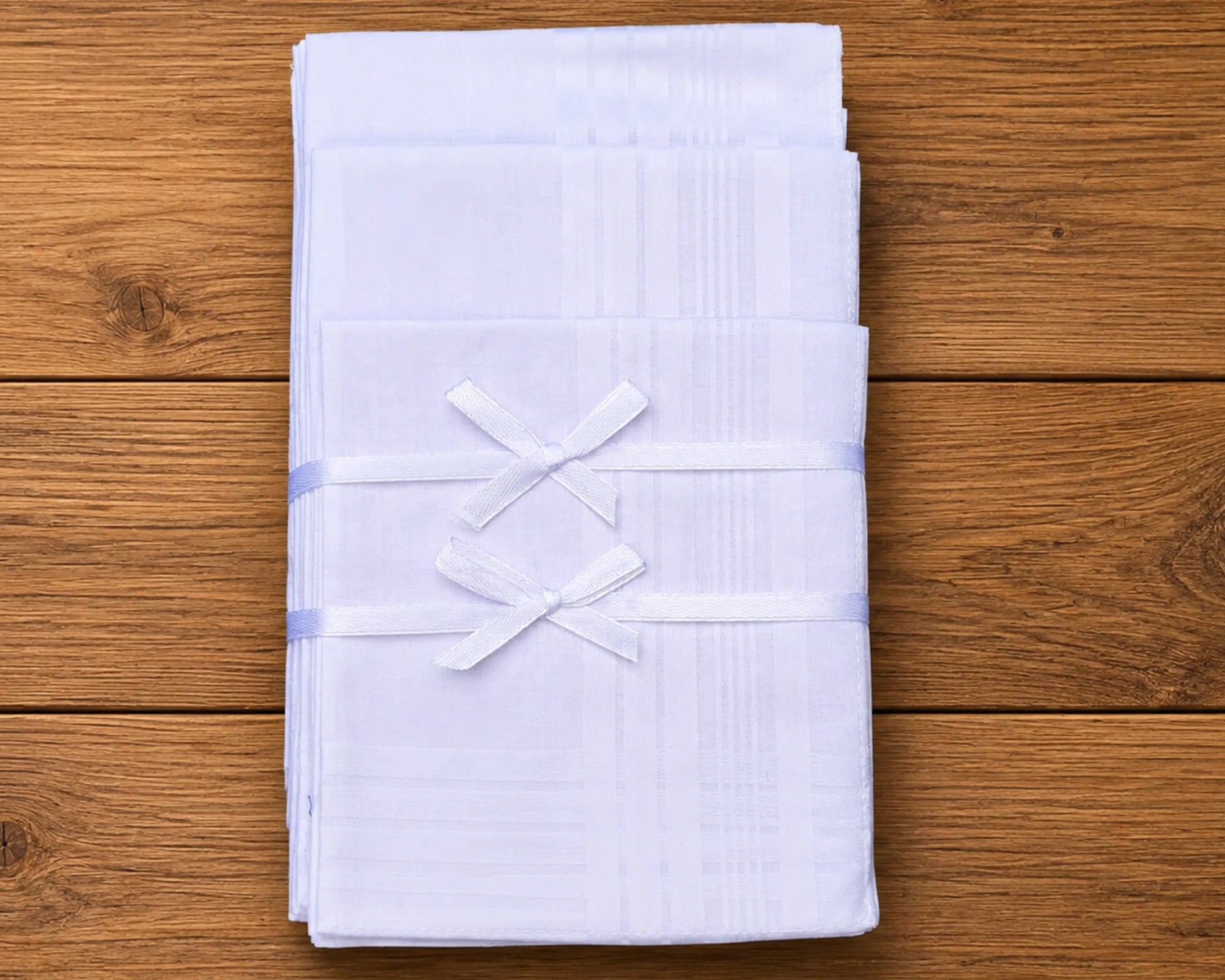 Stack of white folded hanky on a wooden surface