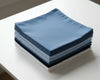 Stack of blue folded hanky on a white surface