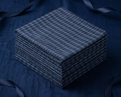 Stack of blue grid design hanky on a dark blue background